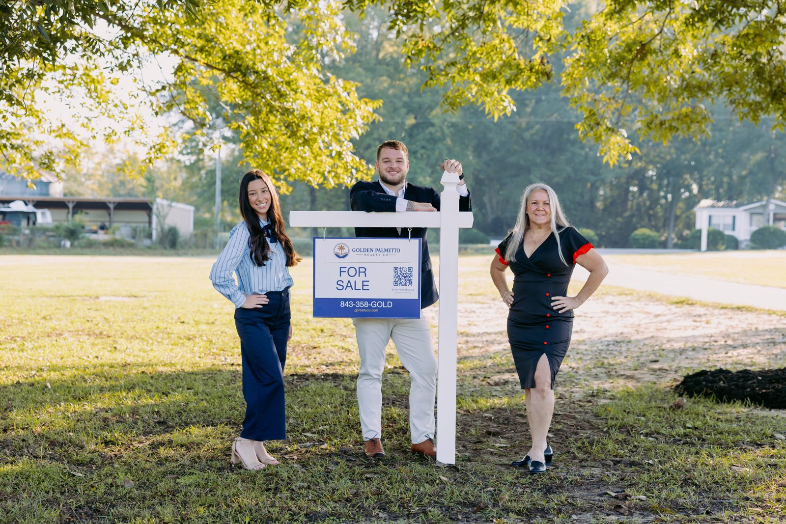 Tonya Moore, Thomas Johnson and Phoebe Johnson of Golden Palmetto Realty with a Golden Palmetto For Sale sign
